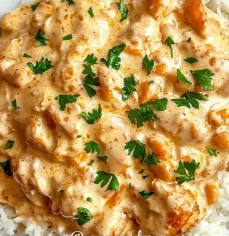Creamy smothered chicken served over rice in a bowl