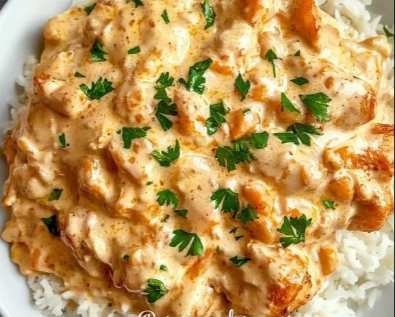 Creamy smothered chicken served over rice in a bowl