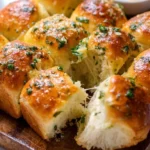 Freshly baked garlic bread rolls topped with parsley and melted butter