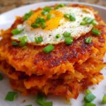 Healthy sweet potato hash browns served on a plate with herbs