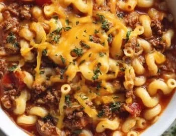 Delicious One-Pot American Goulash served in a bowl with cheese and herbs.