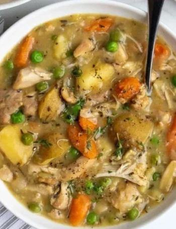 A bowl of hearty slow cooker chicken stew filled with vegetables and tender chicken.