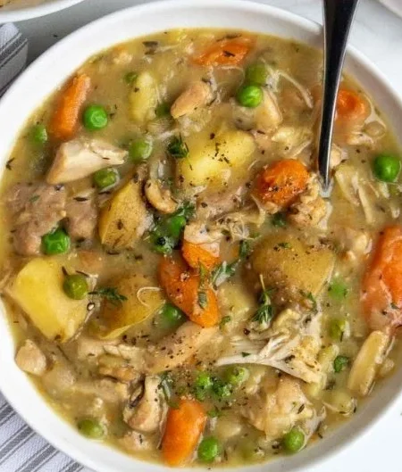 A bowl of hearty slow cooker chicken stew filled with vegetables and tender chicken.