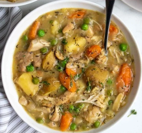 A bowl of hearty slow cooker chicken stew filled with vegetables and tender chicken.
