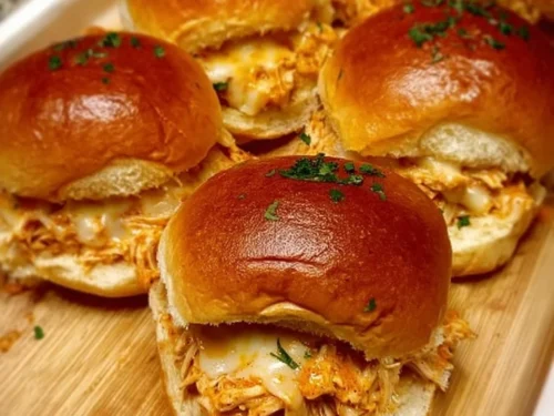 Plate of spicy buffalo chicken sliders garnished with celery and blue cheese