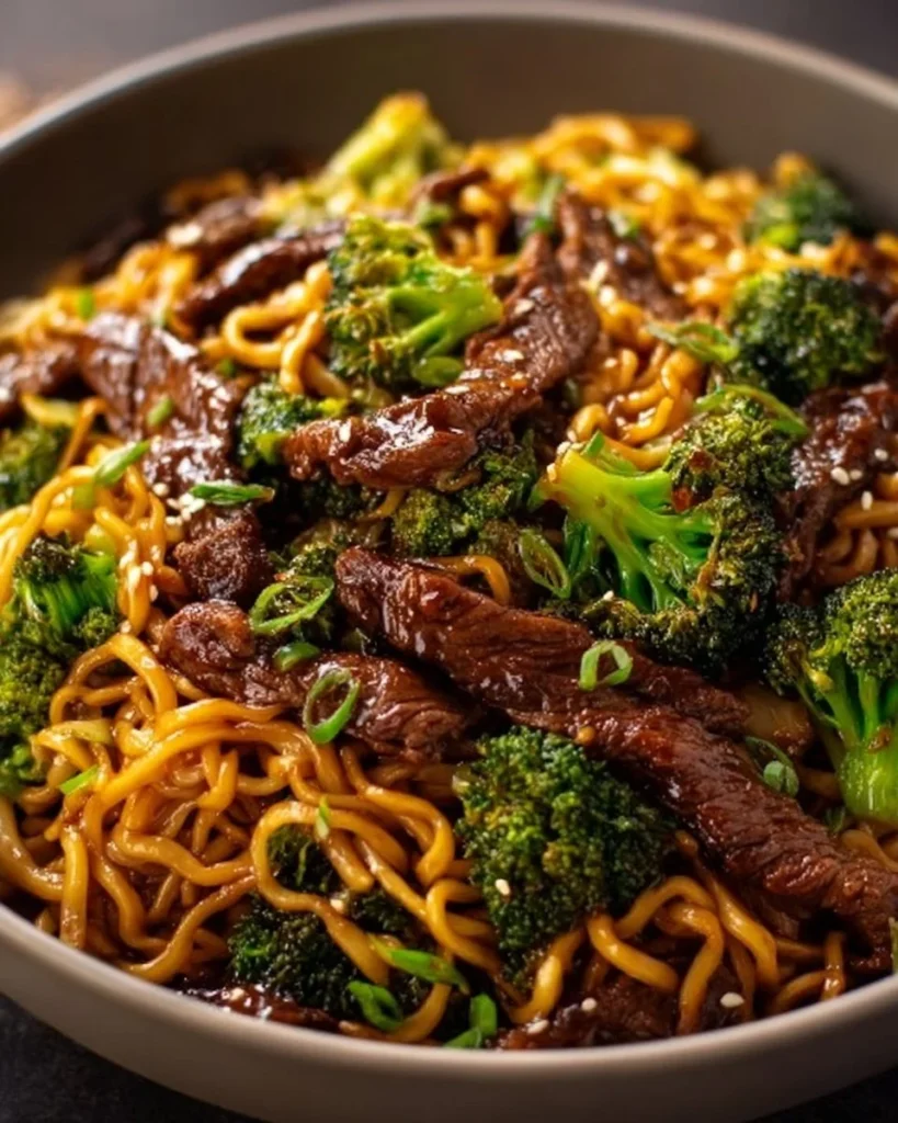 Chinese crispy beef served with broccoli noodles in a bowl