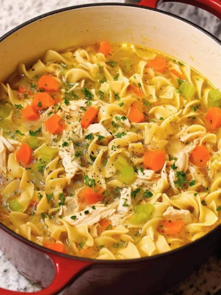 Delicious Dutch Oven Chicken Noodle Soup in a rustic pot