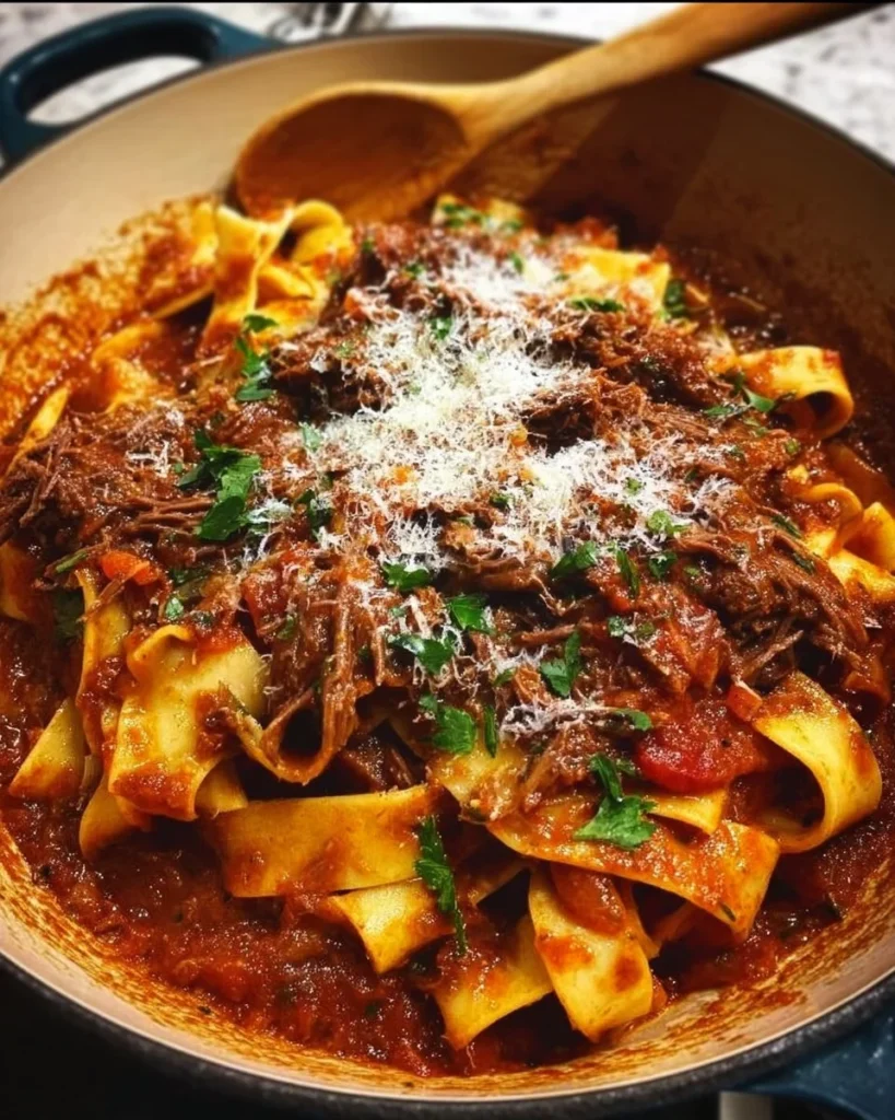 Dutch Oven Short Rib Ragu served over Pappardelle pasta in a rustic dish