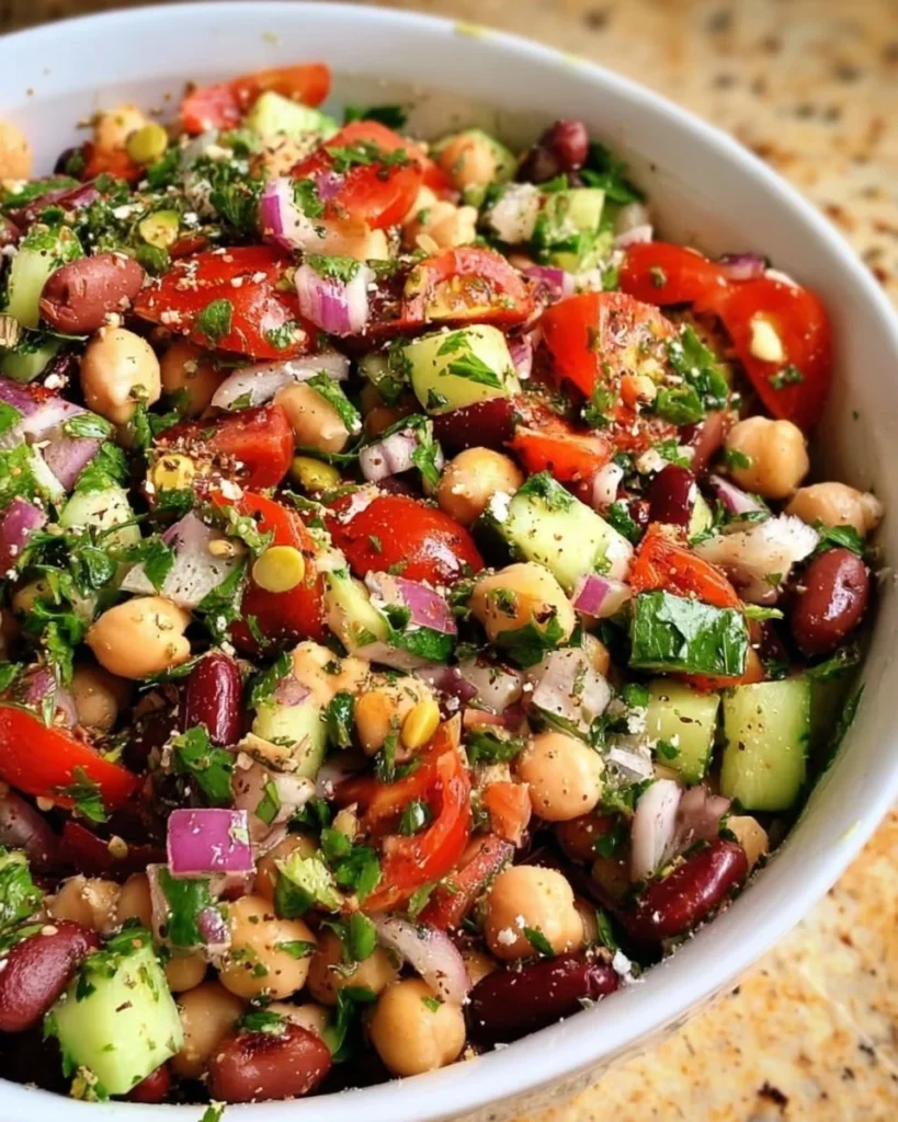 Bowl of colorful Mediterranean Bean Salad with fresh vegetables and herbs