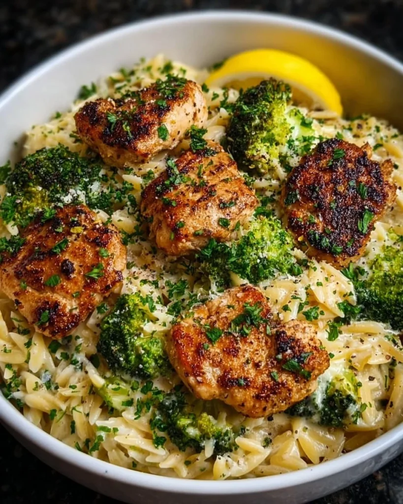 Lemon Pepper Chicken served with broccoli and orzo in a vibrant dish