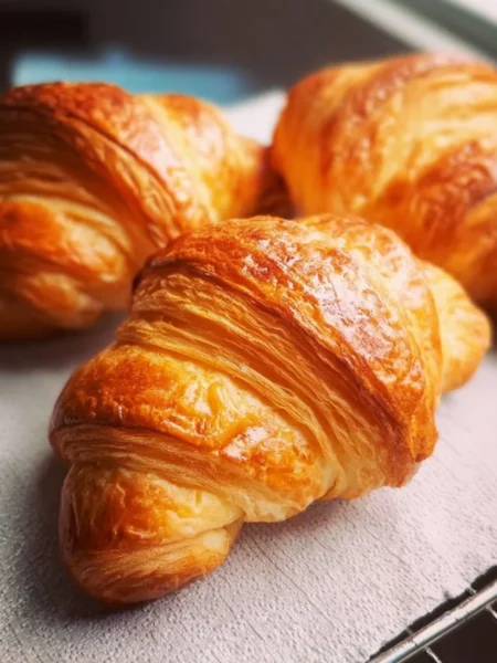Freshly baked tender flaky croissants on a wooden table
