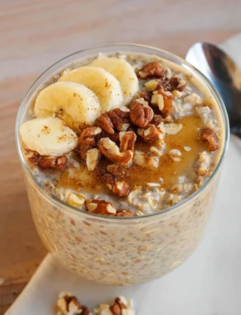 Delicious Banana Bread Overnight Oats in a glass with banana slices on top.