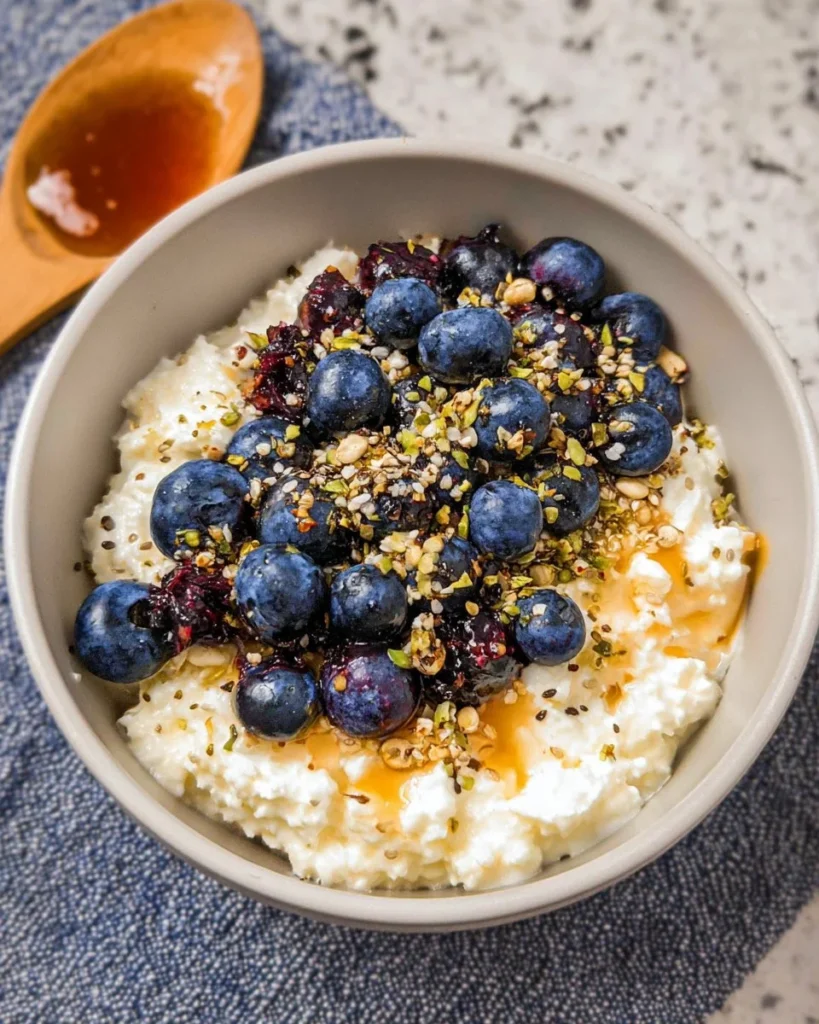 Healthy blueberry cottage cheese bowl topped with fresh blueberries and nuts.