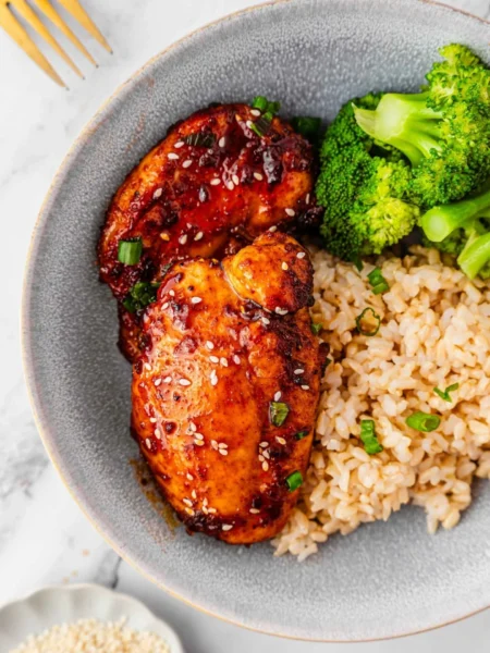 Delicious easy air fryer teriyaki chicken garnished with sesame seeds and green onions.