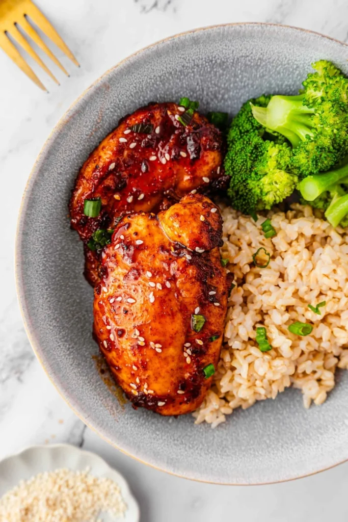 Delicious easy air fryer teriyaki chicken garnished with sesame seeds and green onions.