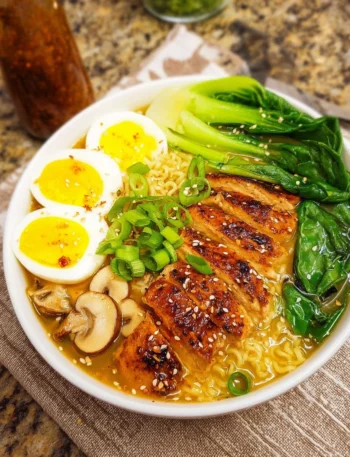 Bowl of easy chicken ramen topped with green onions and boiled egg