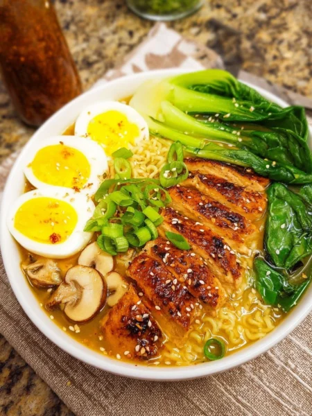 Bowl of easy chicken ramen topped with green onions and boiled egg