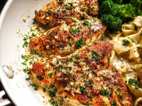 Delicious Garlic Parmesan Chicken served on a plate with herbs.